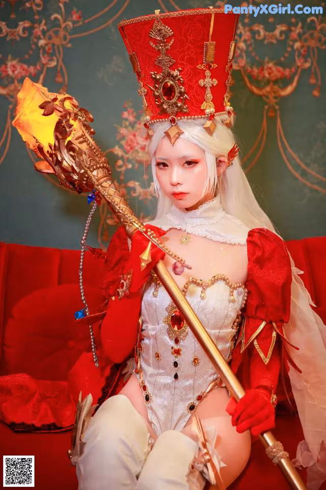 A woman in a red and white outfit holding a staff.