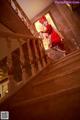 A woman in a red dress is walking up some stairs.