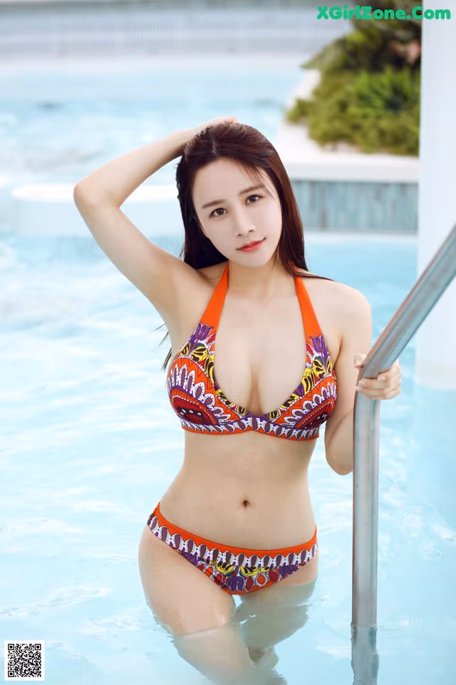 A woman in a bikini standing in a pool.