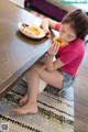 A little girl sitting at a table eating a donut.