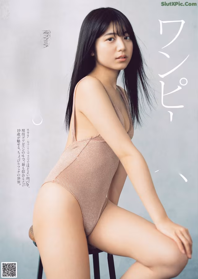 A woman in a pink bathing suit sitting on a stool.