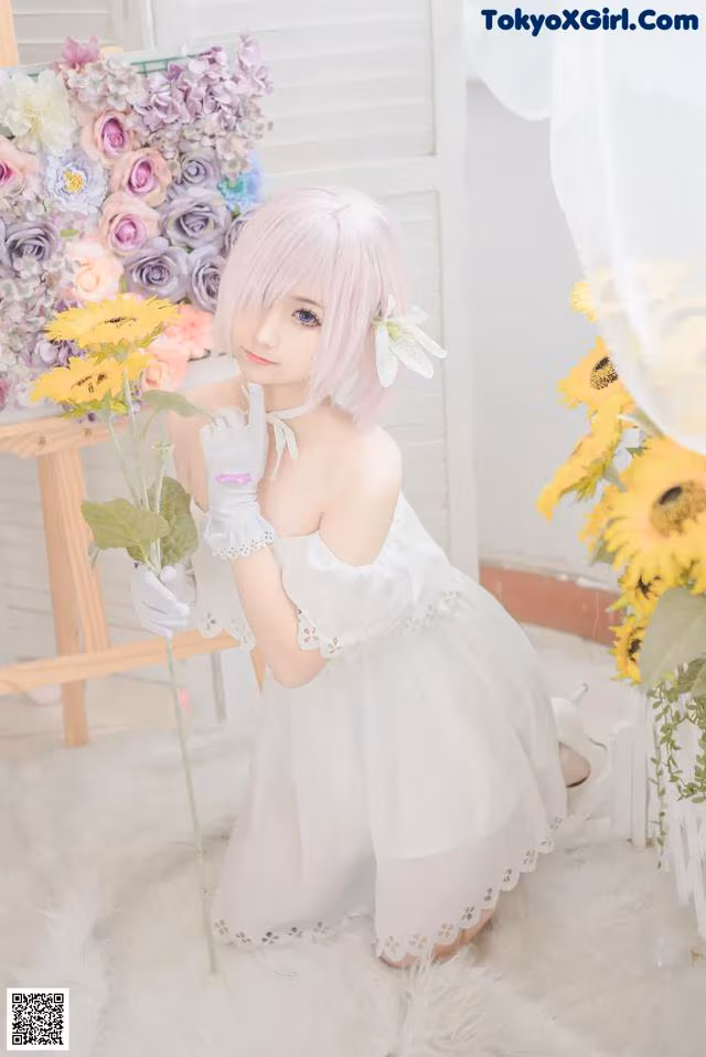 A woman in a white dress holding a bunch of flowers.