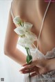 A woman holding a bunch of white flowers in her hand.