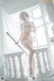 A woman in a white lingerie holding a sword.