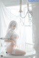 A woman in a white lingerie sitting on a window sill.