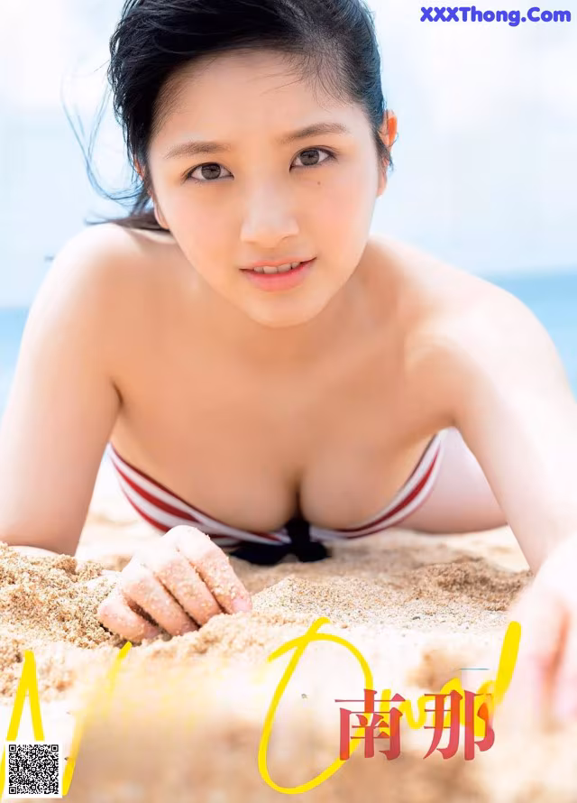 A woman in a bikini laying in the sand on the beach.
