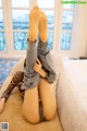 A woman laying on a couch with her legs up in the air.