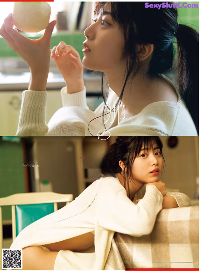 A woman in a white sweater holding an apple in her hand.