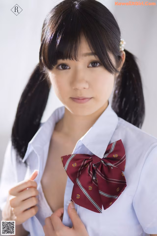A woman in a white shirt and a red bow tie.