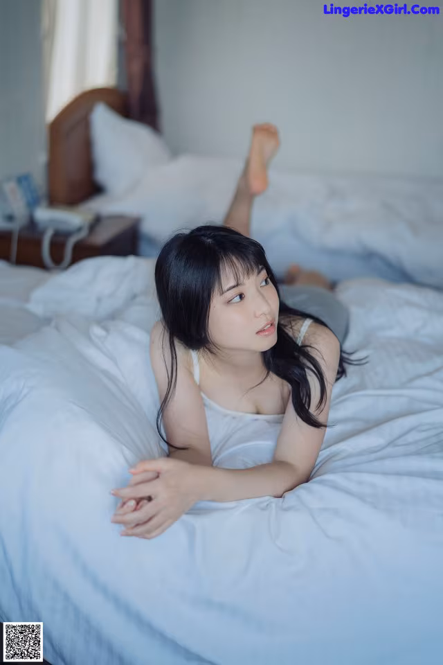 A woman laying on top of a bed in a bedroom.
