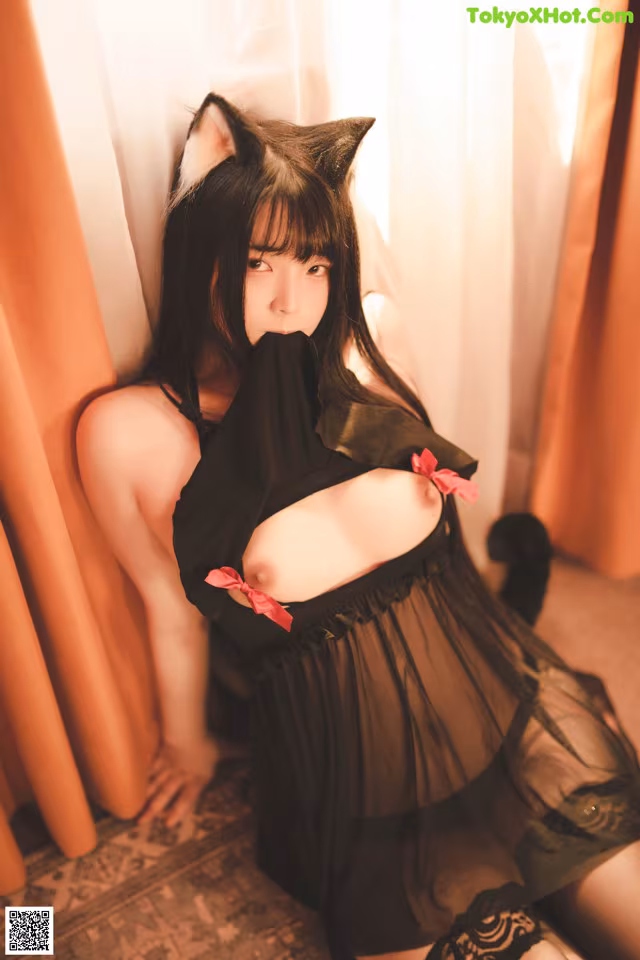 A woman in a black dress with a cat ears on her head.