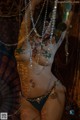 A woman in a bikini with a lot of jewelry on her body.