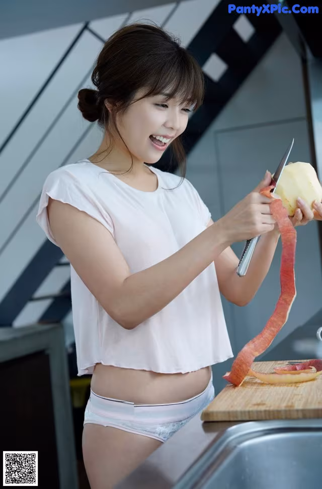 A woman cutting up a piece of fruit on a cutting board.